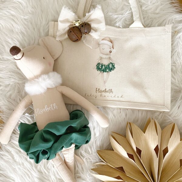 Primer plano mostrando el detalle del nombre personalizado bordado en la bolsa de tela festiva.