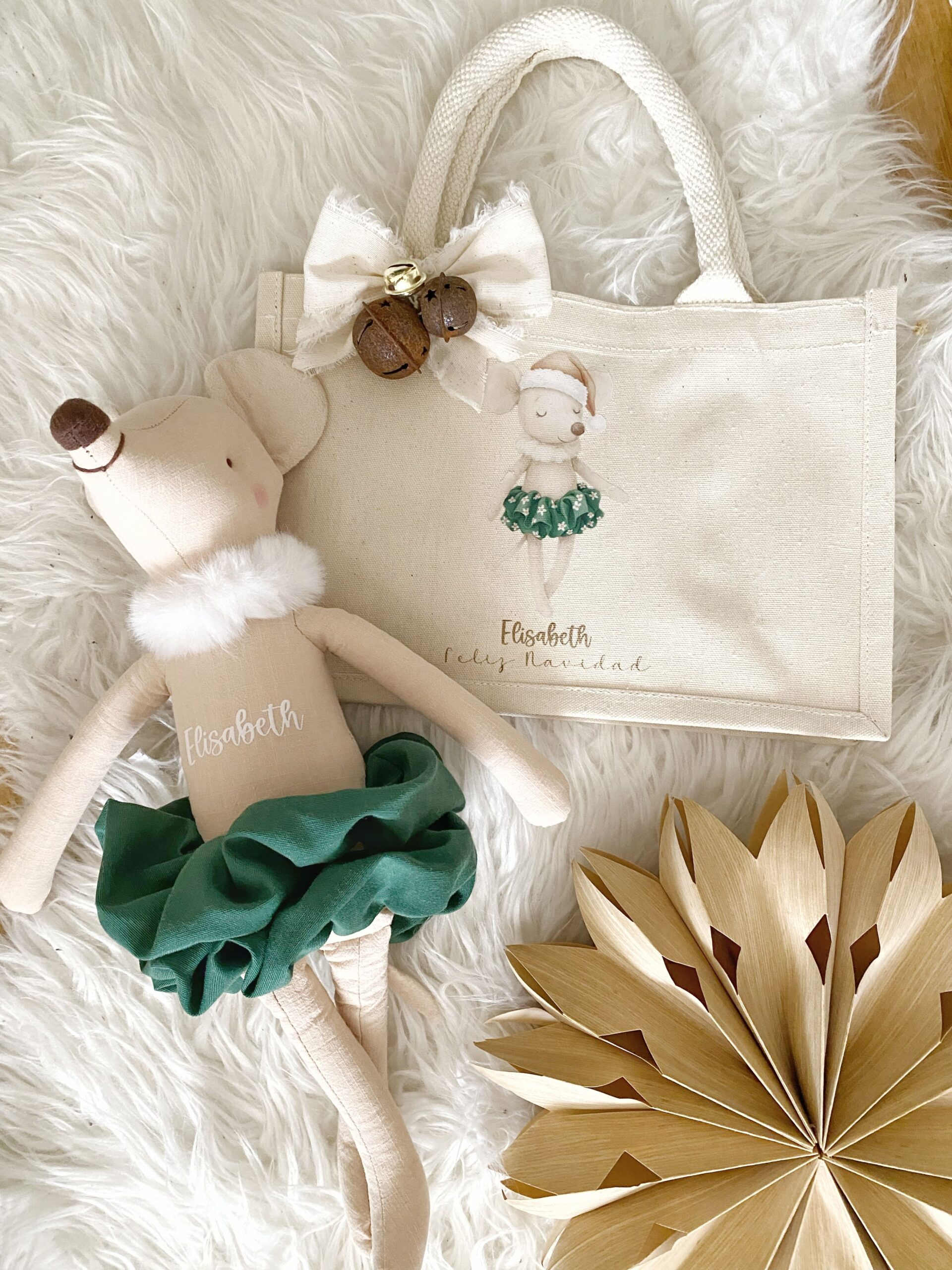 Primer plano mostrando el detalle del nombre personalizado bordado en la bolsa de tela festiva.