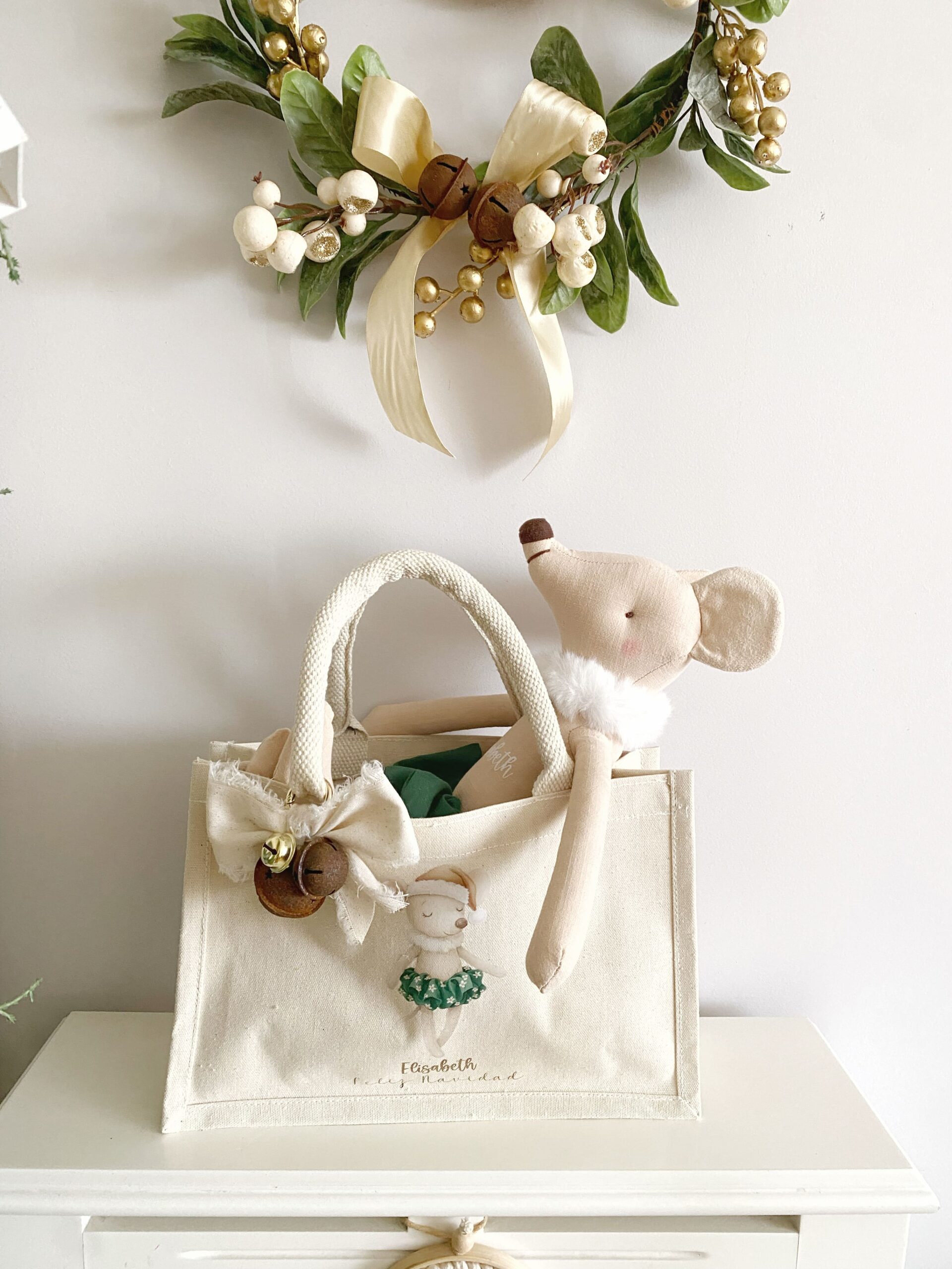 Primer plano mostrando el detalle del nombre personalizado bordado en la bolsa de tela festiva.