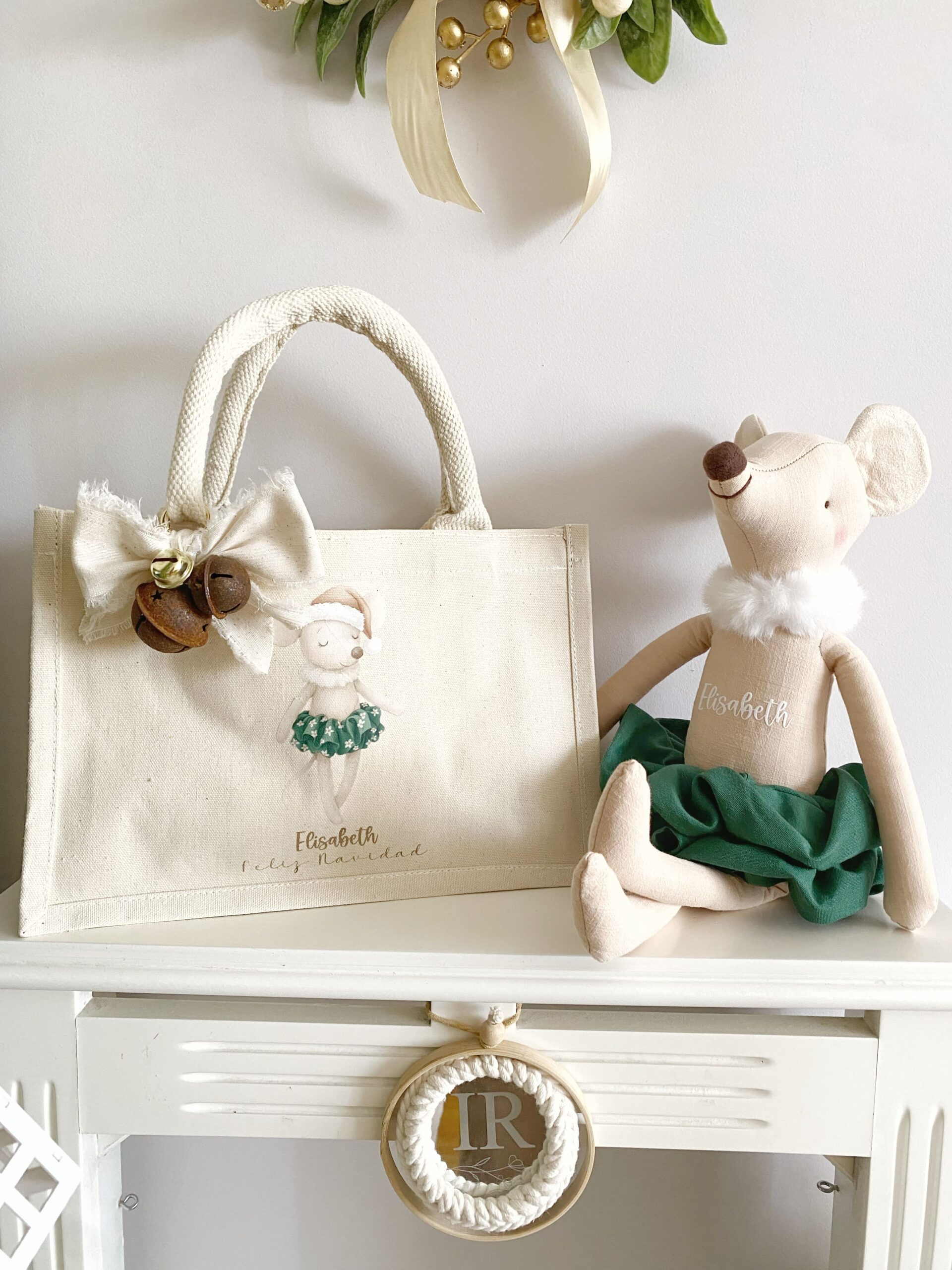 Primer plano mostrando el detalle del nombre personalizado bordado en la bolsa de tela festiva.