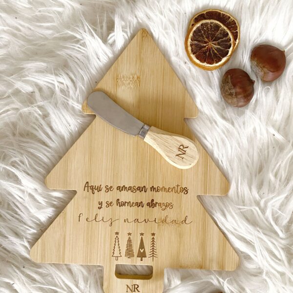Detalle del grabado de las iniciales personalizadas y la frase navideña en la tabla de bambú.