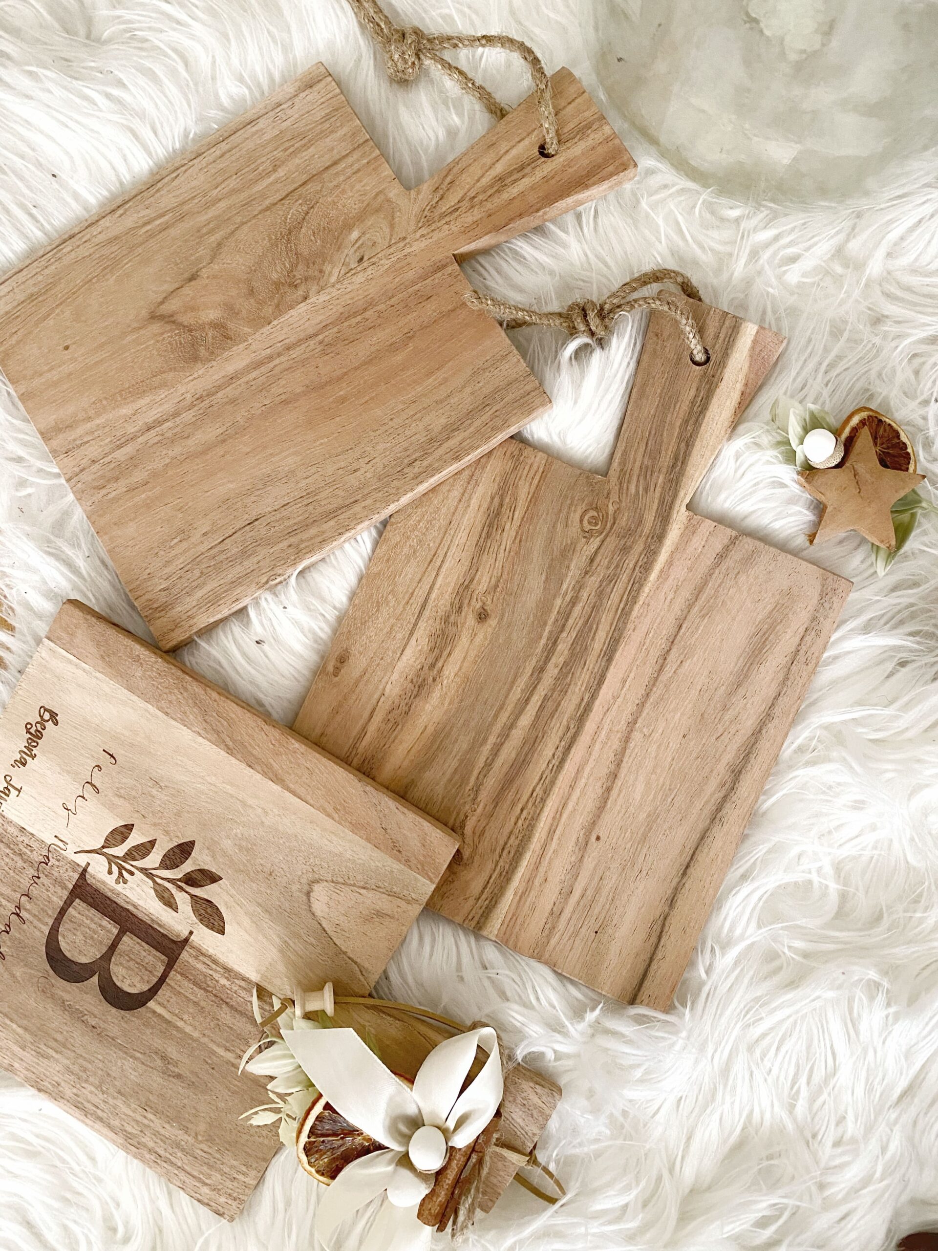 Primer plano mostrando los detalles grabados en la madera de acacia de la tabla navideña, incluye el nombre.