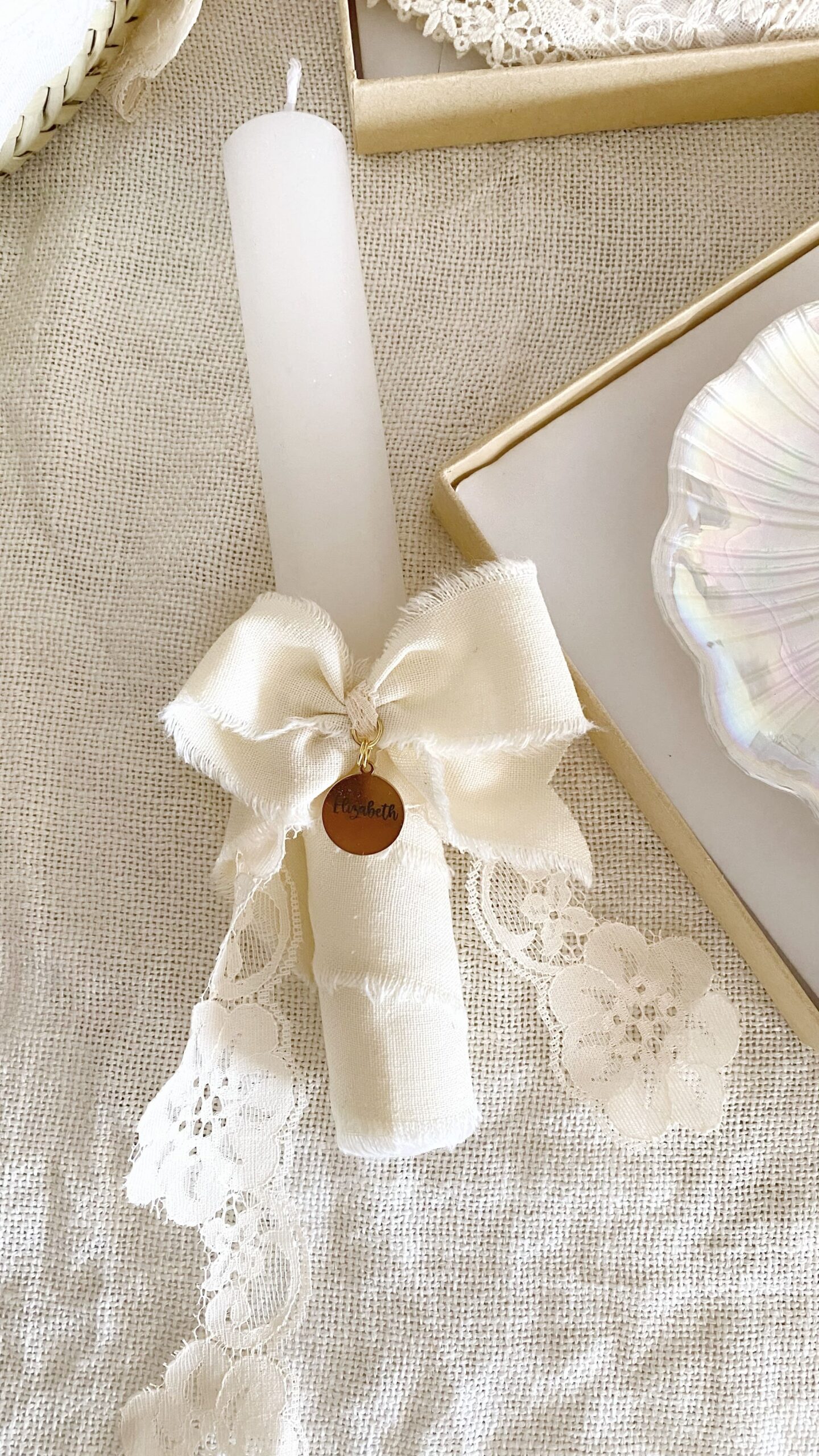 Primer plano de la vela de bautizo decorada y personalizada con nombre y fecha.