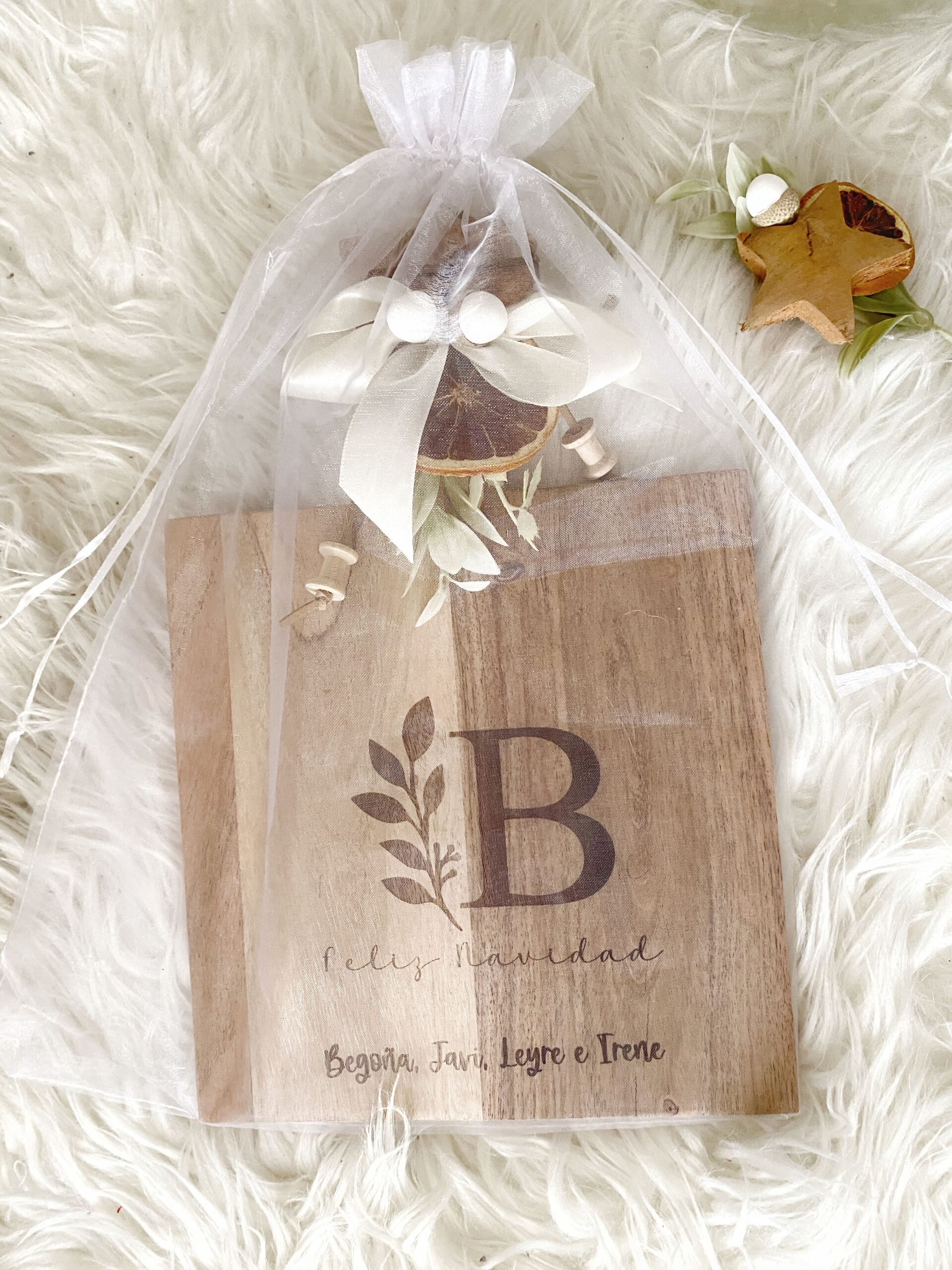 Vista general de la tabla de cocina de acacia, decorada con piñas y una frase navideña personalizada para la ocasión.