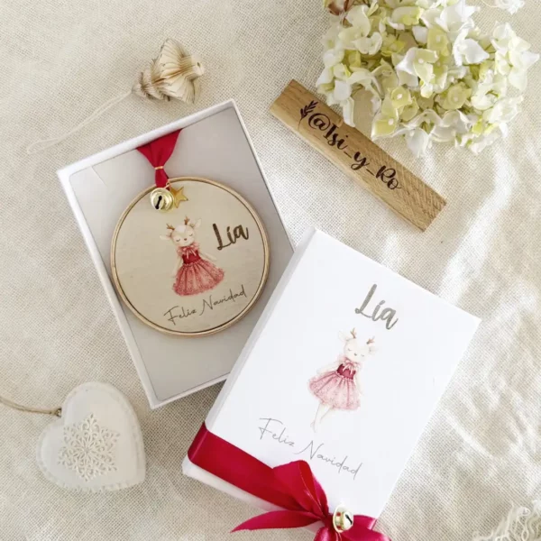 Bola de Navidad personalizada con nombre y ciervo en acuarela, dentro de su caja regalo con lazo rojo y cascabel dorado