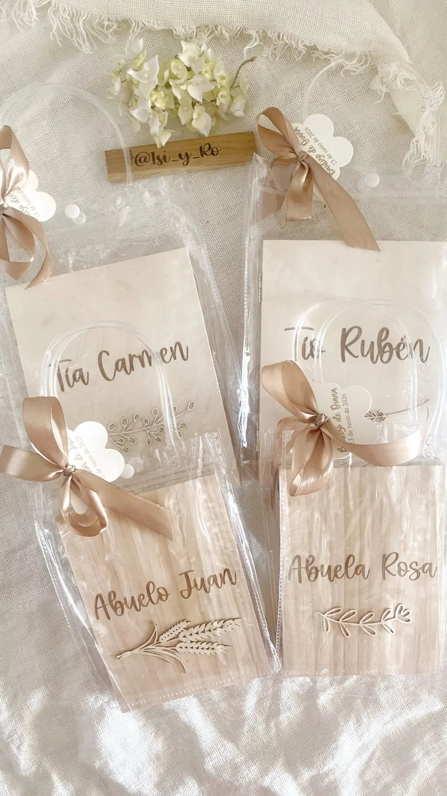 Cuatro álbumes de madera con nombres de familiares en bolsas de regalo transparentes con lazo y etiqueta