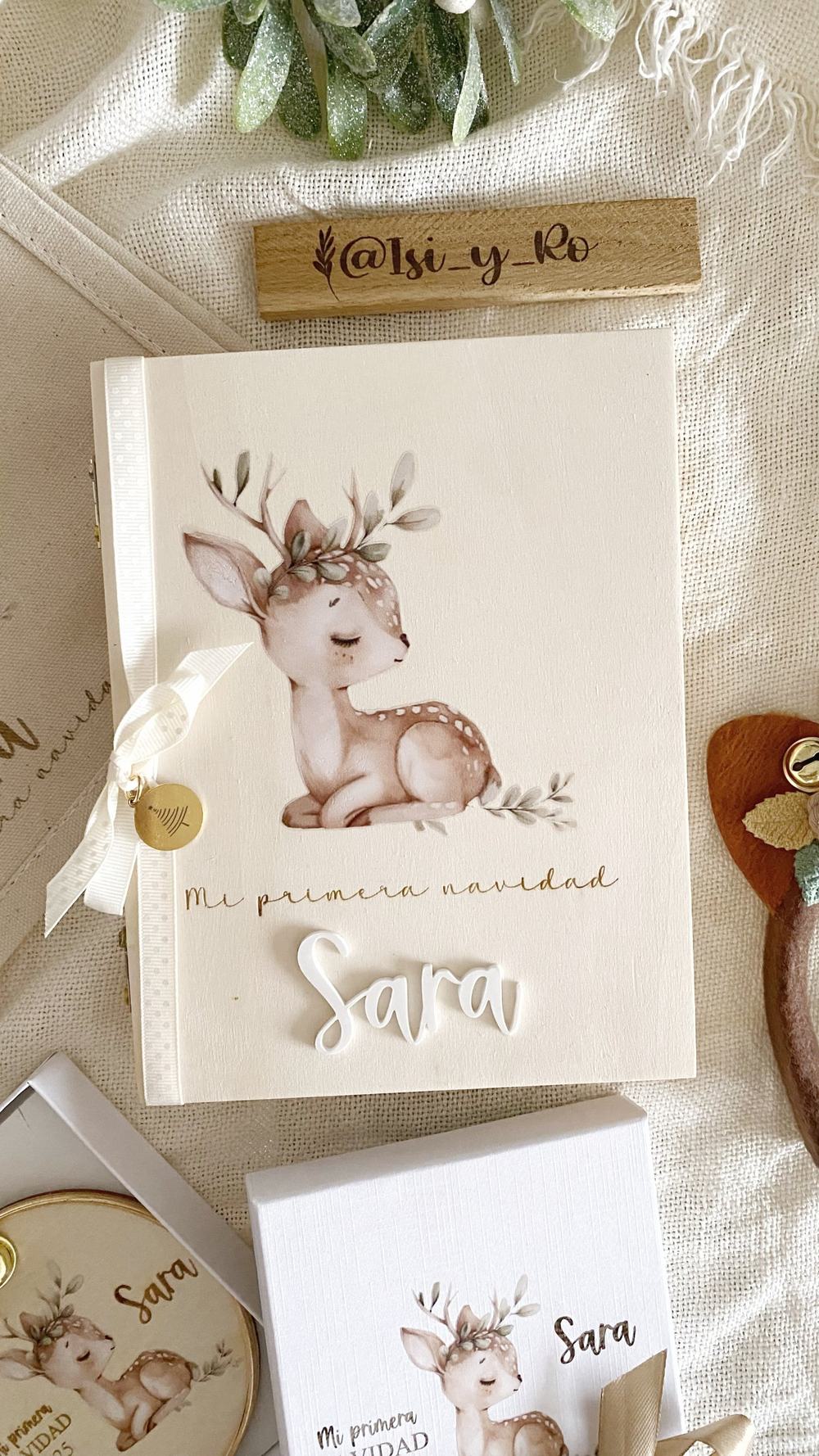 Portada del álbum de madera con cervatillo, Mi primera Navidad en dorado, nombre en metacrilato y lazo con medalla