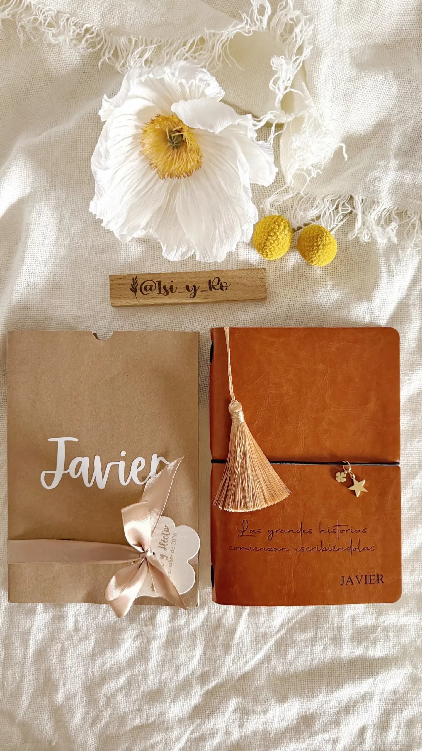 Cuaderno de cubierta efecto piel con borla junto a su funda kraft personalizada con nombre y lazo