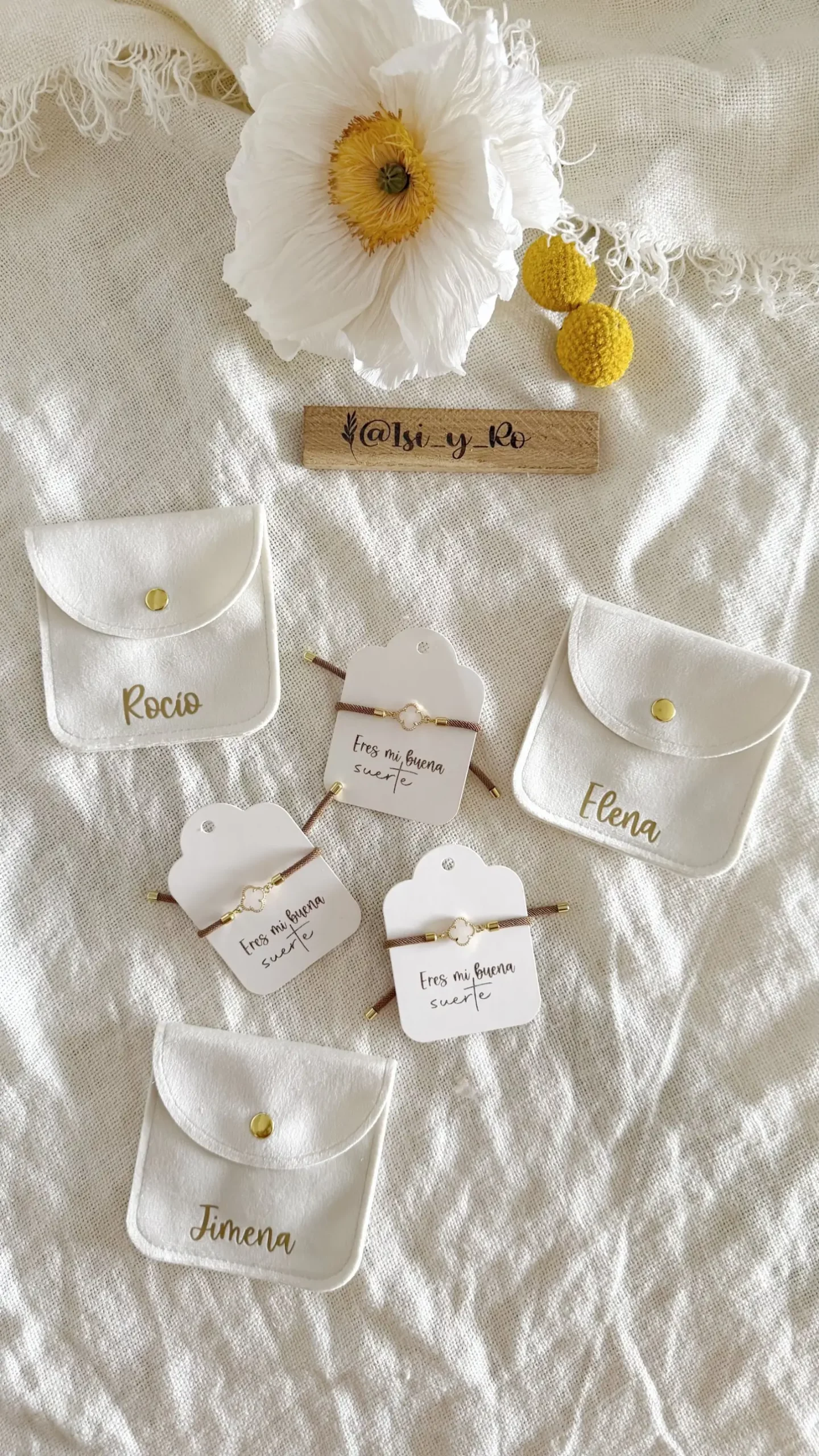 Detalle de pulseras de cordón marrón con trébol de nácar y dorado sobre tarjeta "Eres mi buena suerte"